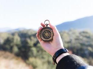 Stock photo of a hand holding a compass