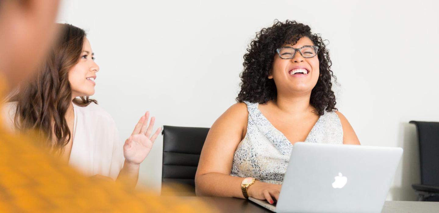 Student with curly hair laughing with peers